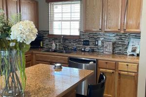 奥马哈Entire residential home -Omaha的厨房配有木制橱柜和花瓶,