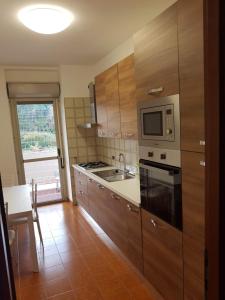 罗马Casa Stazione Magliana的厨房配有木制橱柜、微波炉和桌子