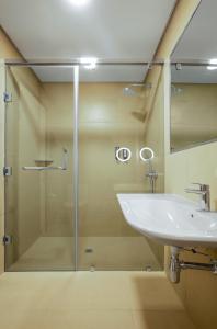 拉各斯Nordic Hotel Lagos的一间带玻璃淋浴和水槽的浴室