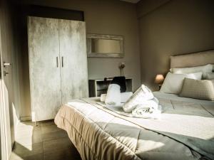 阿利韦里翁Villa Marelia apartments的一间卧室配有两张带毛巾的床