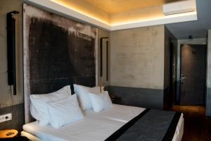 帕特雷阿多尼斯城市酒店的卧室配有带白色枕头的大床