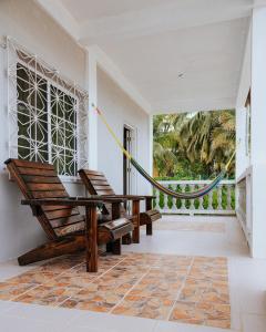 蓬塔戈尔达Wanigi Guesthouse的门廊配有2把椅子和吊床