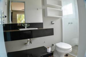卡皮托利乌Cantinho da Alegria Suítes的一间带卫生间、水槽和镜子的浴室