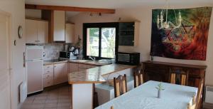 利和米克斯Landes OCEANES - Chambres privées dans villa avec jardin的厨房配有桌子和白色冰箱。