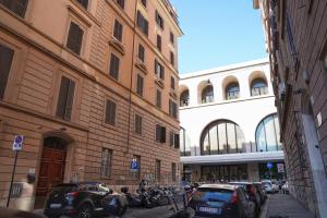 罗马Archi di Roma Guest House的一条城市街道,汽车停在大楼旁边