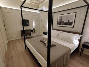 摩德纳La Bella Modena Centro的一间卧室配有四柱床和一张书桌