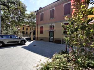 摩德纳La Bella Modena Centro的停在大楼旁边的停车场的汽车