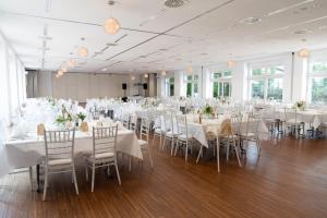 里登瑞奇弗杜纳艾尔贝酒店的宴会厅配有白色的桌椅