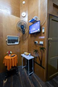 曼谷Sip N' Camp的一间设有桌子的房间和墙上的电视