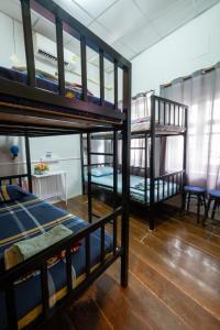曼谷Sip N' Camp的客房设有三张双层床和一张桌子。