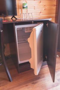 皮聪达AMSHIN-Pitsunda的书桌下的开放式冰箱,配有电视