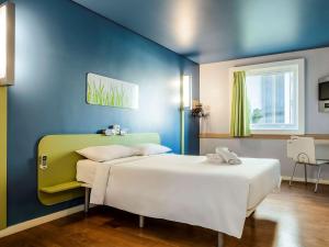 贝洛奥里藏特ibis budget Belo Horizonte Afonso Pena的一间卧室设有两张床和蓝色的墙壁