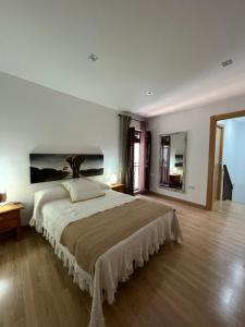 莫纳奇尔Casa rural Los Abuelos的一间卧室配有一张大床,墙上挂着一幅大画