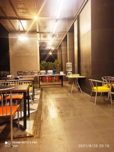 浦那StayBird - B Suite, Business Hotel, Kharadi的用餐室配有桌椅和灯光