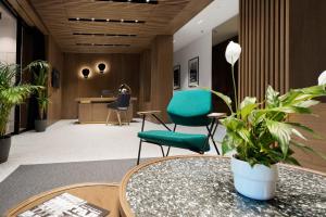 贝尔格莱德Dominic Smart & Luxury Suites - Edition的一个带绿色椅子和桌子的办公室