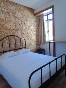 菲盖拉-达福什QuimPecável的卧室配有白色的砖墙床
