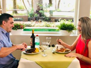 伊瓜苏港格兰托比伦酒店的坐在餐桌旁吃食物的男人和女人