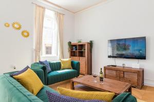 普拉Apartment Augier - Elegant & Spacious - City Centre的客厅配有两张绿色沙发和一张桌子