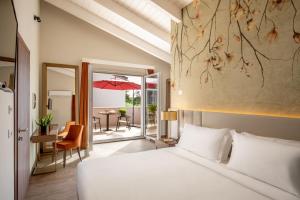 阿韦扎诺Hotel Della Piana的一间卧室配有一张床和一张带雨伞的桌子