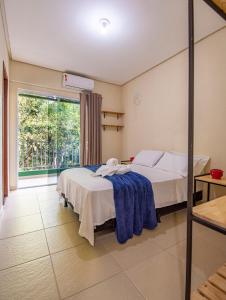 伦索伊斯Village Brasil, Lençóis的一间卧室设有两张床和大窗户