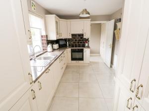 韦斯特波特Curragh Hill的厨房配有白色橱柜和水槽