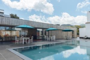 卡佩拉什索拉孔迪酒店的一个带桌椅和遮阳伞的游泳池
