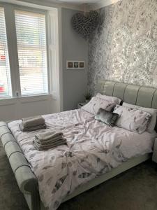 RentonWoodvale Flat, Renton, Loch Lomond的一间卧室配有一张大床和枕头