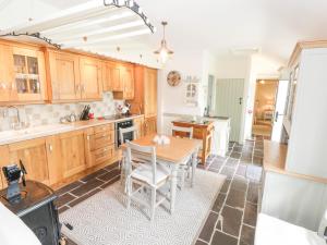 博伊尔Lakeside Cottage的厨房配有木制橱柜和桌椅