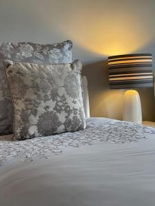 LattonGreenfields Country House的一间卧室配有一张带枕头和灯的床