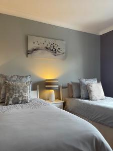 LattonGreenfields Country House的一间卧室配有两张床和一盏灯