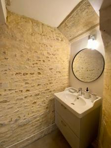 库尔瑟勒·苏尔·梅尔Chambres d'hôtes Le Maroni的一间带水槽和镜子的浴室