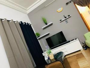 科托努PARADISE 2的客厅配有平面电视和窗帘