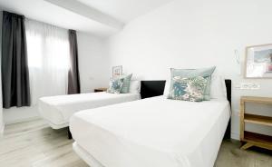 科拉雷侯Island Home Fuerteventura的白色的客房设有两张床和窗户。