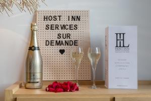 里昂HOST INN - CŒUR VIEUX LYON & SPA的一瓶香槟和一张桌子上的两杯酒