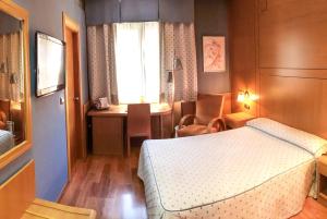 格拉纳达格拉纳达赖诺酒店的一间卧室配有一张床、一张书桌和一个窗户。
