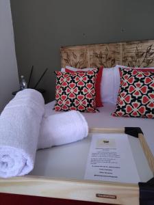 圣若热岛Sítio Aroeira Chalés的床上的毛巾,带枕头和菜单
