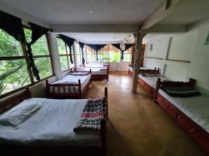 圣马科斯拉拉古纳Casa AHAU的一间带三张床的卧室和一间带窗户的房间