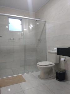 蒙特韦尔迪Chalés Recanto Vista do Valle的一间带卫生间和玻璃淋浴间的浴室