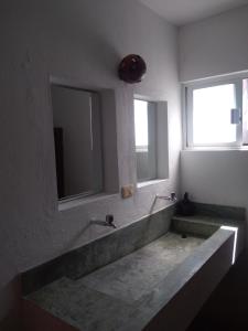 玛哈威Hostal Jardin的一间带大水槽和大镜子的浴室
