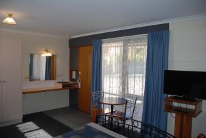 莱克斯恩特伦斯坎宁安海岸金链汽车旅馆的酒店客房设有桌子和窗户。
