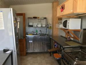 安库德Ancud Petit Hostal的小厨房配有冰箱和微波炉。