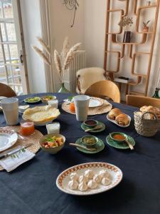 尼奥尔Chambres d'hôtes - La Maison 19的一张蓝色桌子,上面放着食物板