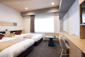 仓敷Hotel Grand Cocoe Kurashiki的酒店客房设有两张床和窗户。