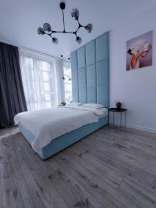 利沃夫AVALON on Lypynskogo street (New building)的一间卧室配有一张大床和蓝色床头板
