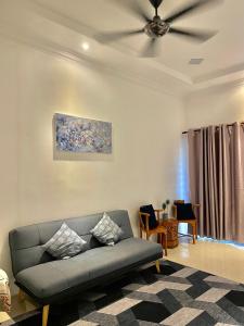 波德申HnR HOMESTAY PORT DICKSON的带沙发和吊扇的客厅