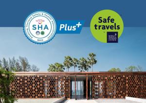 卡马拉海滩The Naka Phuket, a Member of Design Hotels - SHA Extra Plus的带有安全旅行标志的建筑