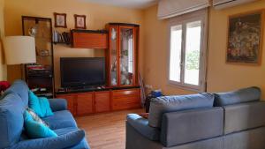 塞古德卡拉斐Apartamento con piscina y bonita terraza的客厅配有2张蓝色沙发和1台电视