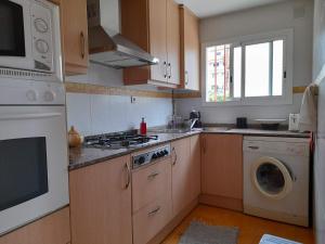 塞古德卡拉斐Apartamento con piscina y bonita terraza的厨房配有炉灶和洗衣机。