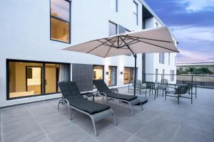 拉各斯Nordic Hotel Lagos的庭院配有桌椅和遮阳伞。