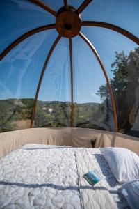 VrmdžaRtanj hotel sa 1000 zvezdica 2的一张位于带大窗户的帐篷内的床铺